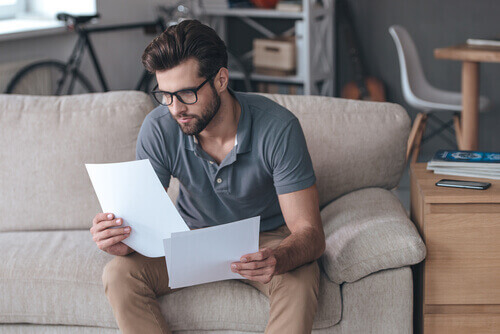 Young man reading legal paperwork